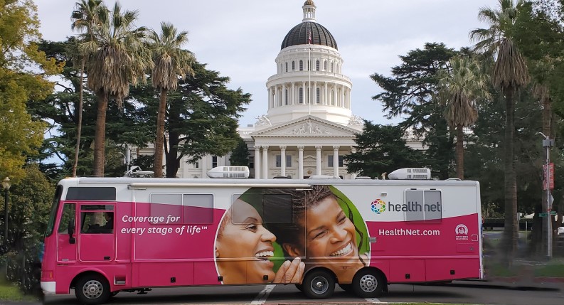 Clínica RV (vehículos recreativos) de vacunación móvil de Health Net frente al edificio del Capitolio del Estado de California