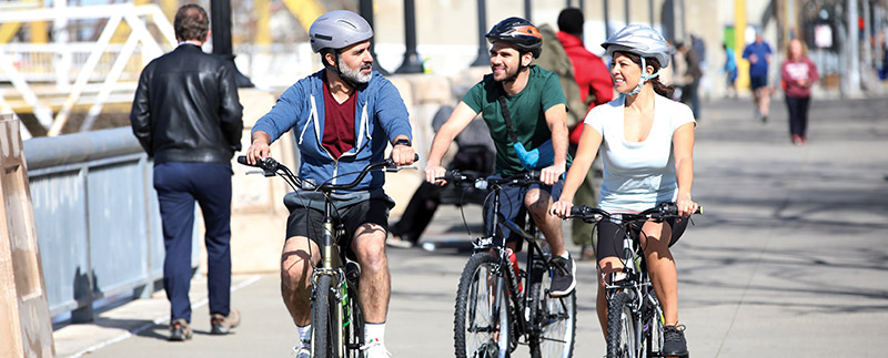 Two men and one woman bicycle riding 